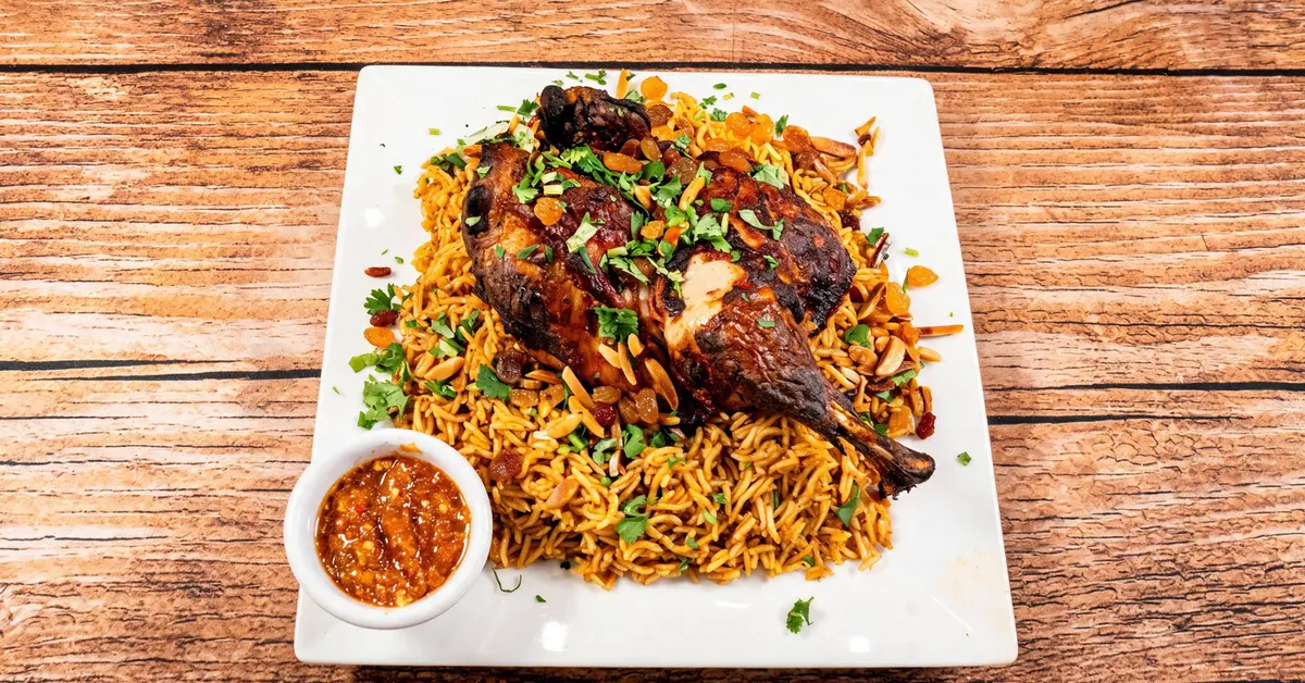Chicken kabsa: roasted half chicken over spiced rice with raisins and toasted almonds