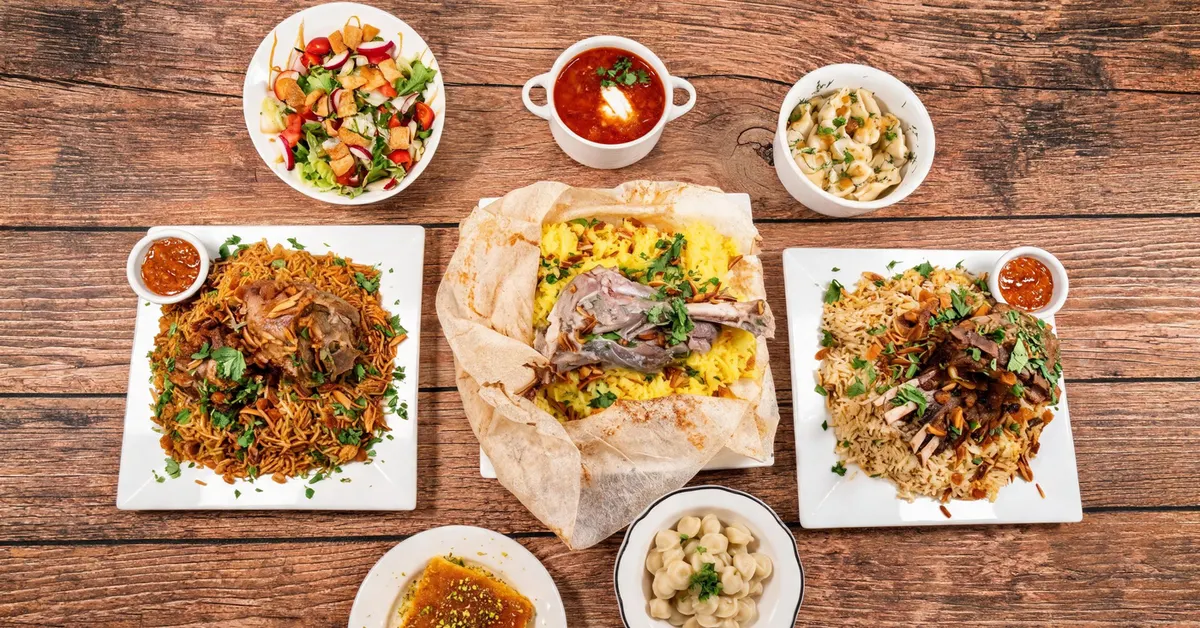 A SimSim table spread: lamb over rice three ways, salad, borshch, dumplings, and kunafa