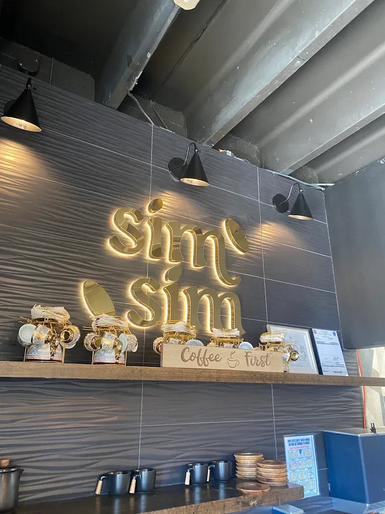SimSim neon logo sign above the coffee bar