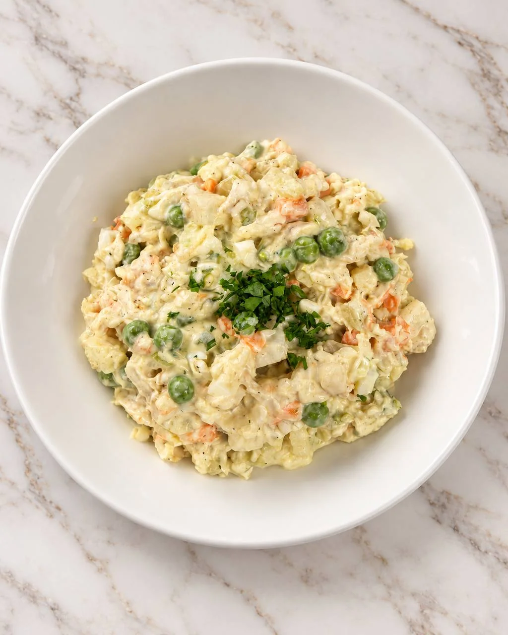 Olivier salad with peas, carrots, herbs, and a creamy dressing